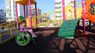 Tekerlekli sandalyesi bulunan minik Zeynep'in yüzü gülüyor