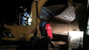 Hafriyat yüklenen kamyon iş makinesinin üzerine devrildi