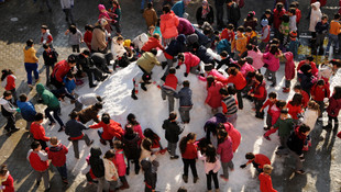 Okul bahçesine çocuklar için kamyonla kar taşındı