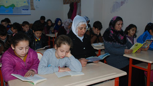 Öğrenci, öğretmen ve veli birlikte kitap okuyor