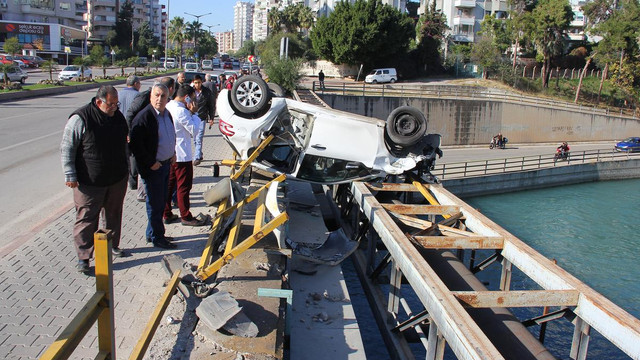Kaza yapan otomobil kanal korkuluğunda asılı kaldı
