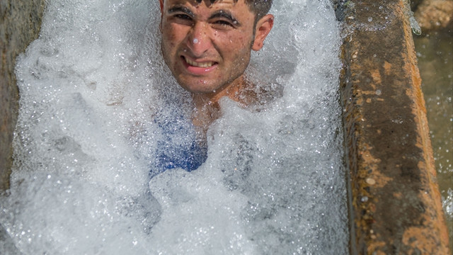 Sıcaktan bunalan çocuklar süs havuzlarında serinledi